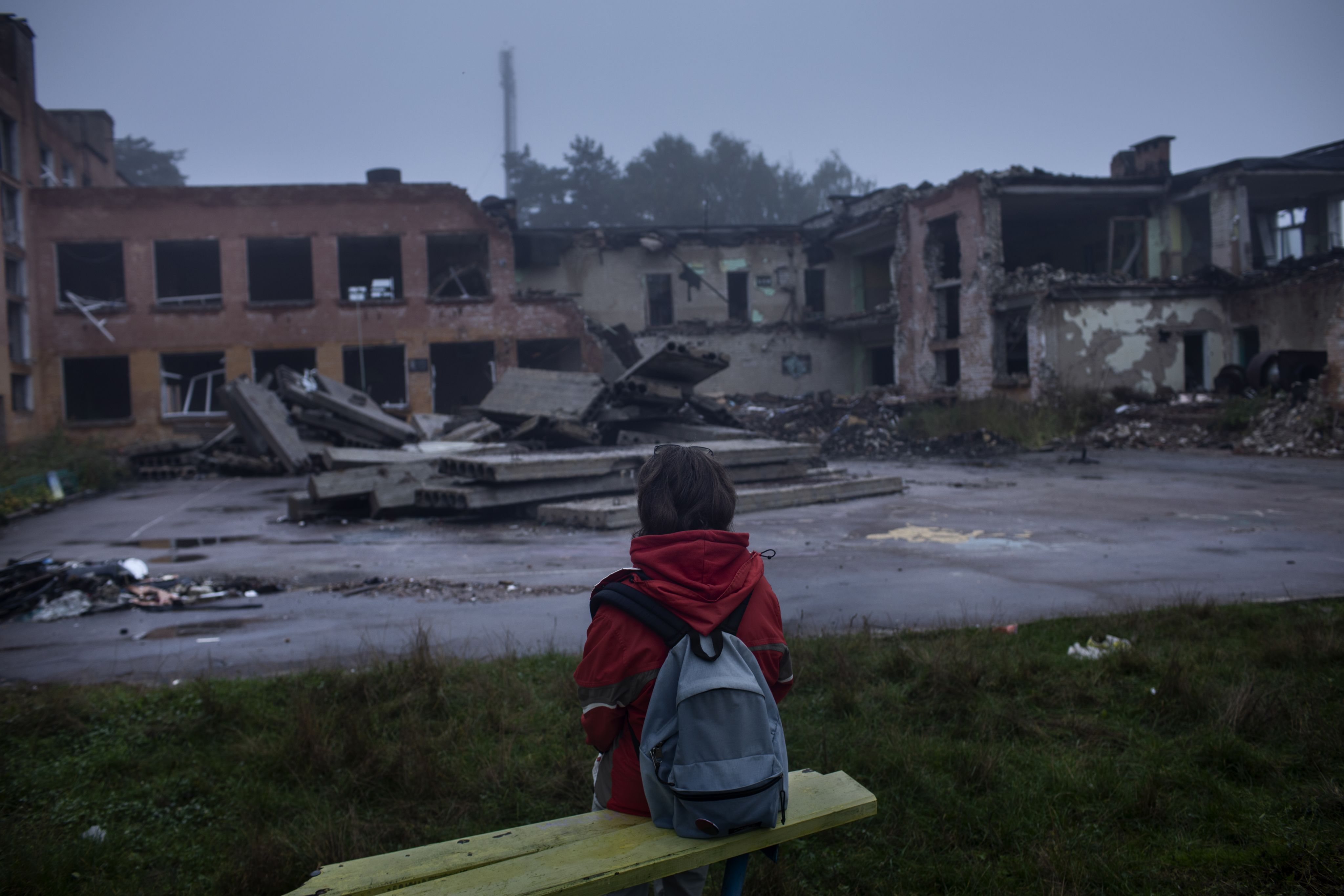 Daria stands with her back to the camera looking at the remains of her school.
