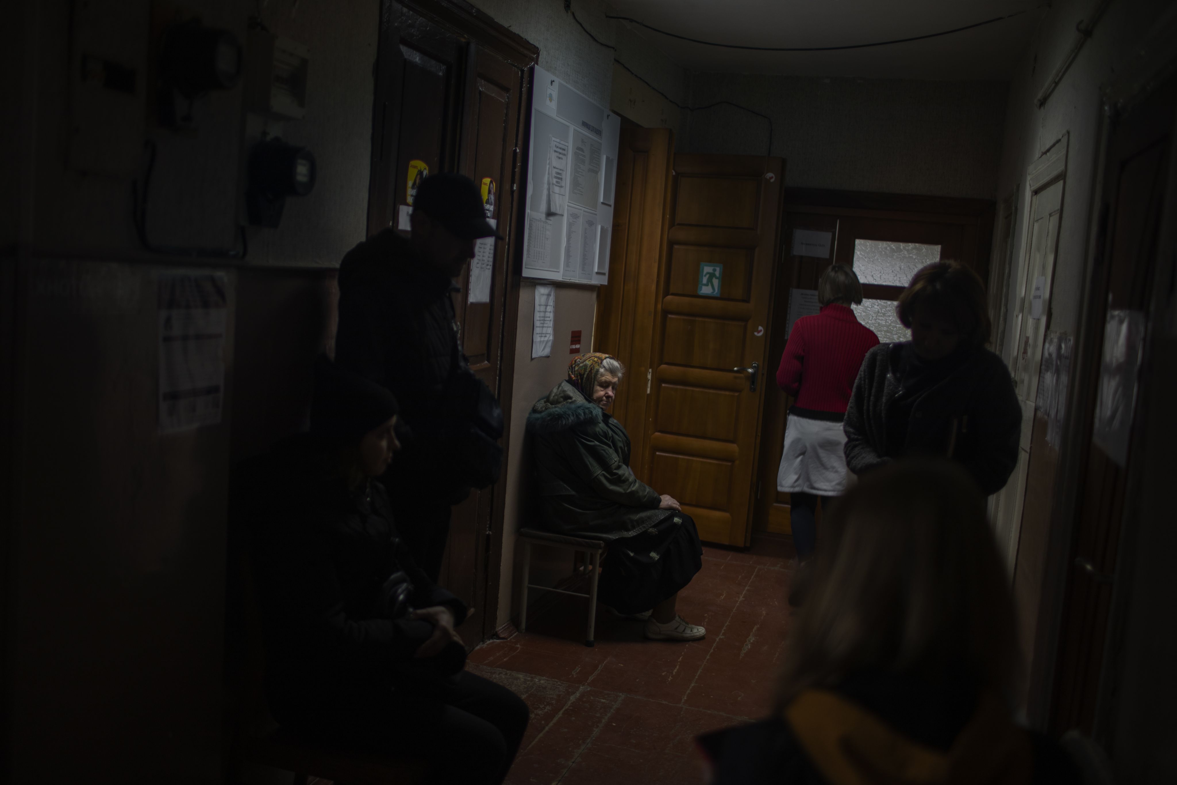 Patients wait in a narrow corridor to be treated.