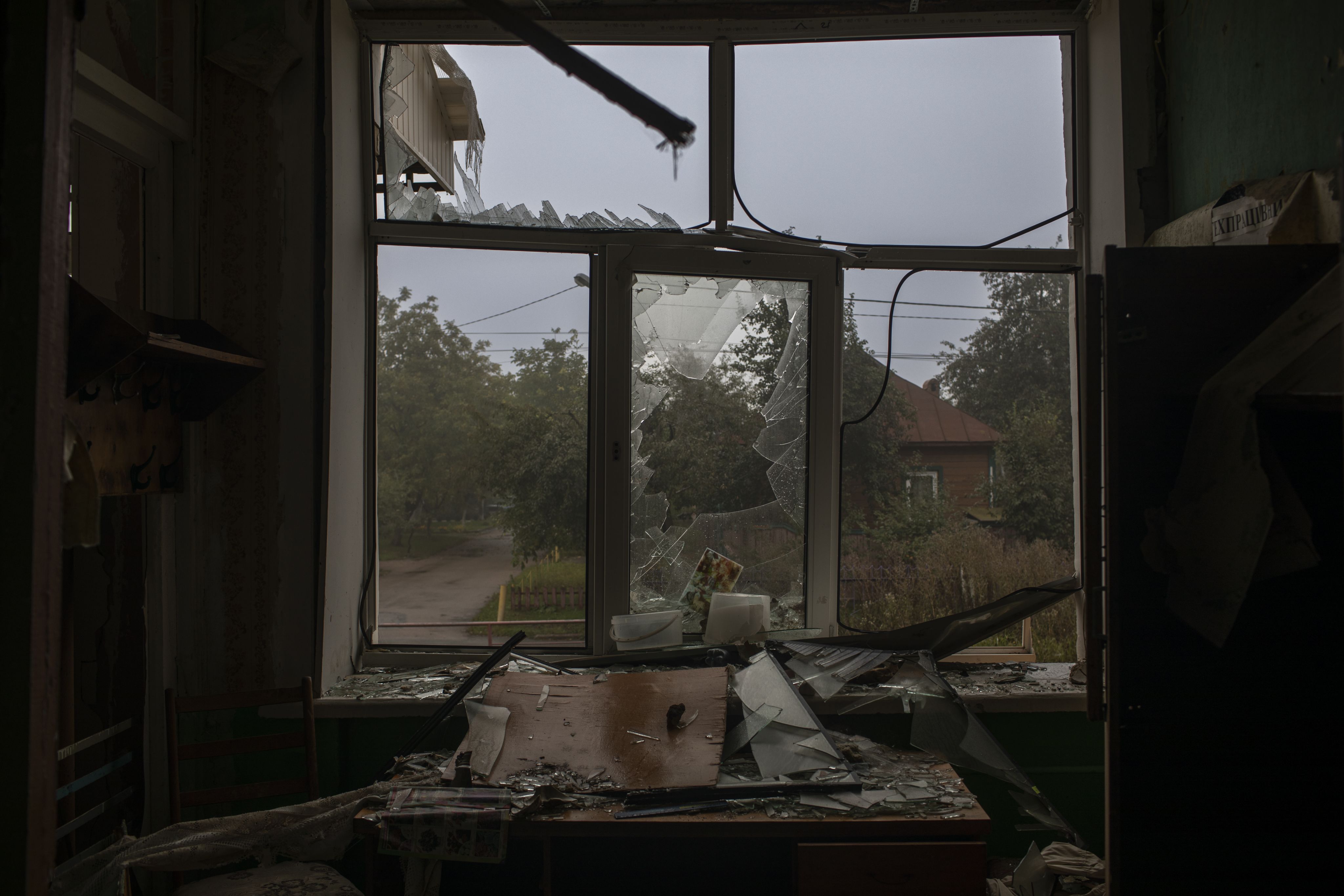 A shattered window is pictured from the inside of a classroom.
