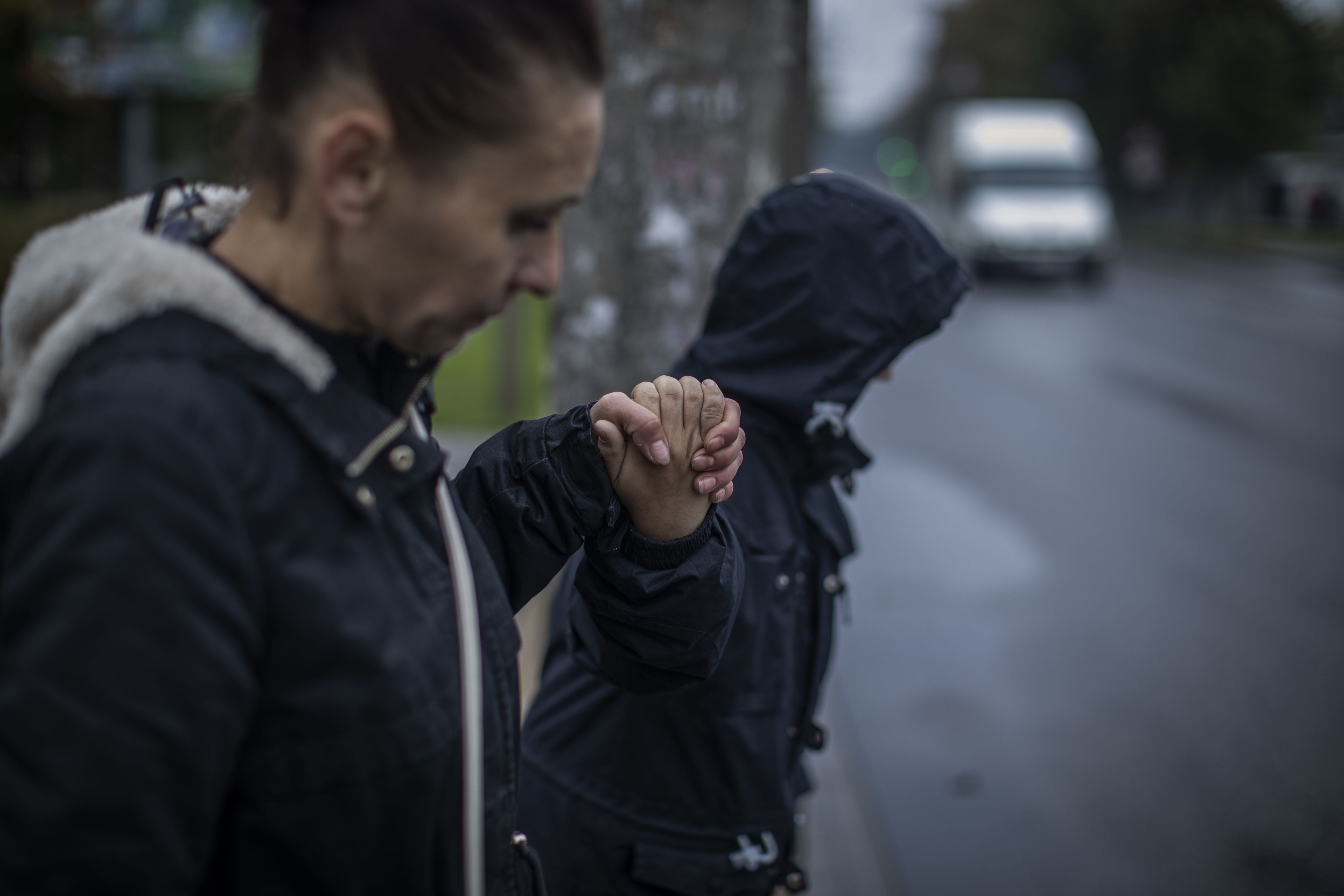 Olena, left, holds her son's hand as they cross the street.