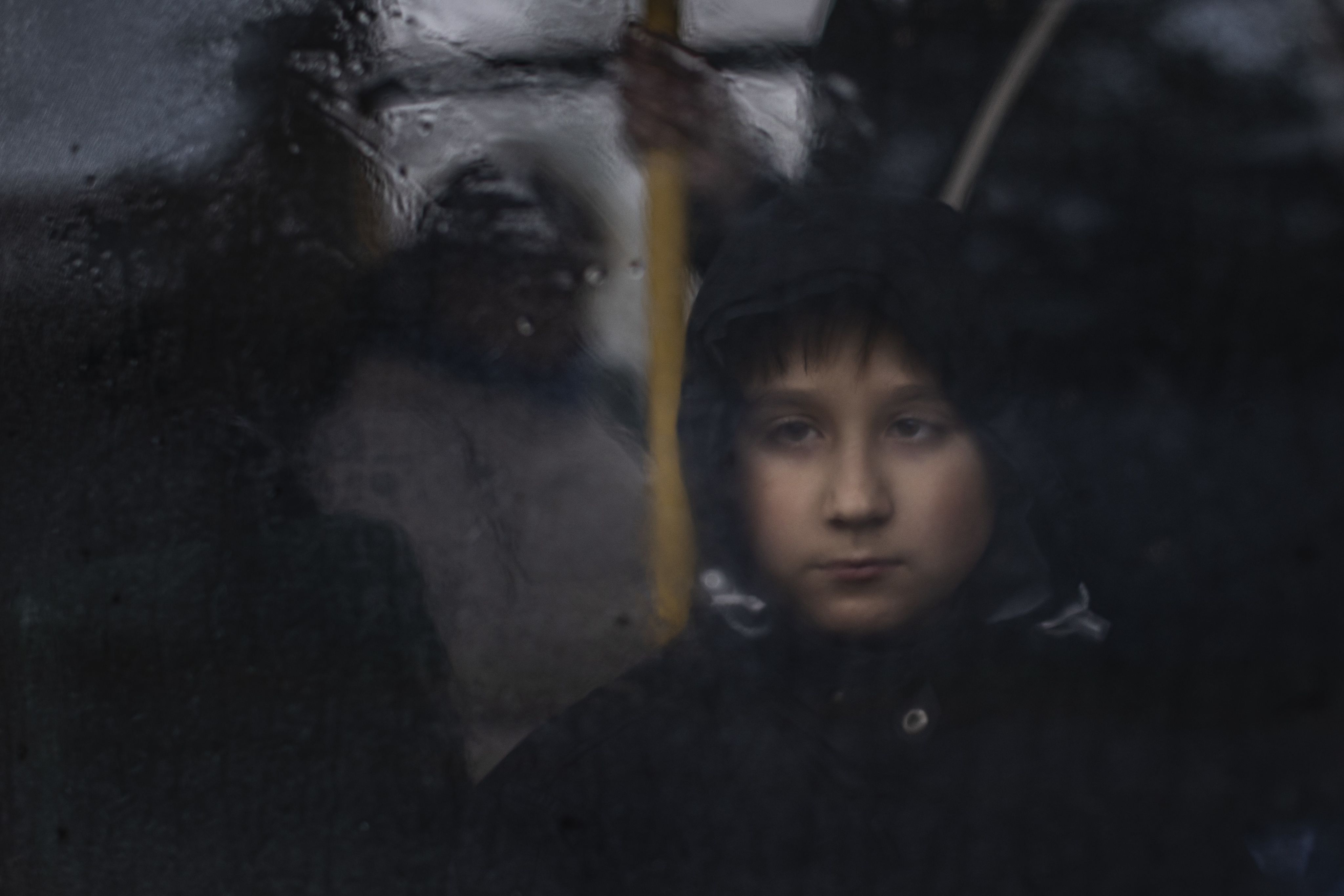 A boy looks out of the window of a bus in Ukraine.