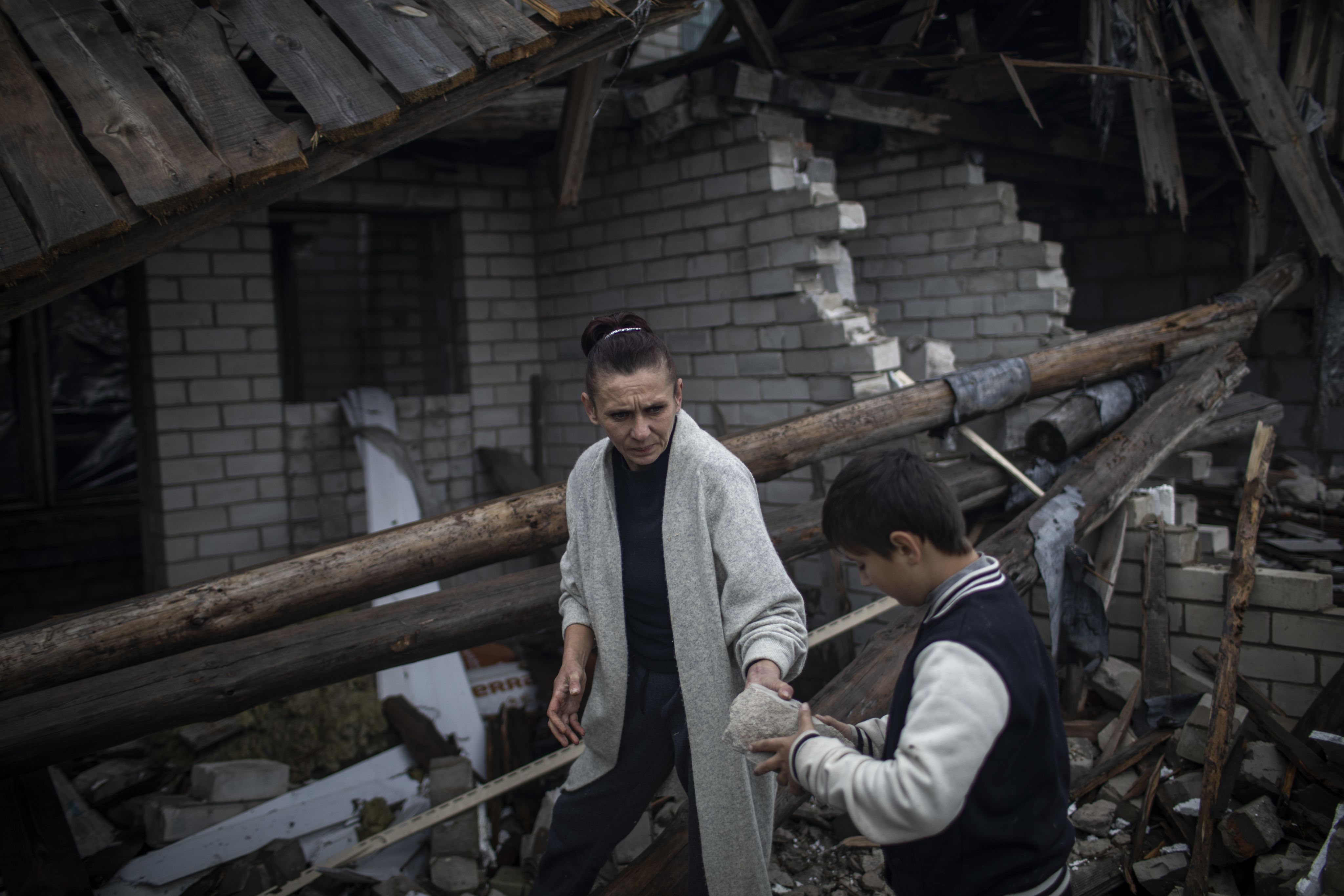 Olena, left, and Misha clear rubble from the remains of their badly damaged house.